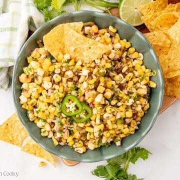 Finished copycat Chipotle corn salsa in a bowl next to tortilla chips.