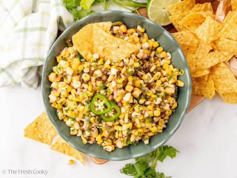 Finished copycat Chipotle corn salsa in a bowl next to tortilla chips.