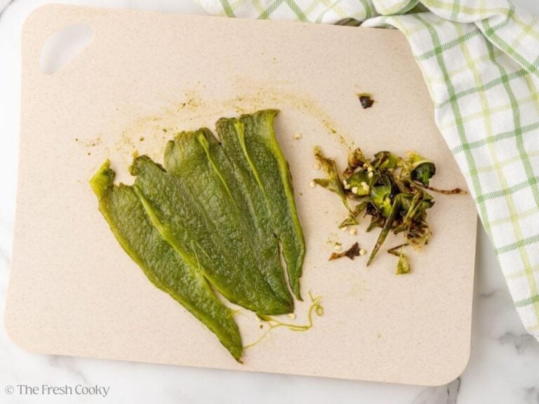 Seeds removed from the roasted poblano pepper on a cutting board.