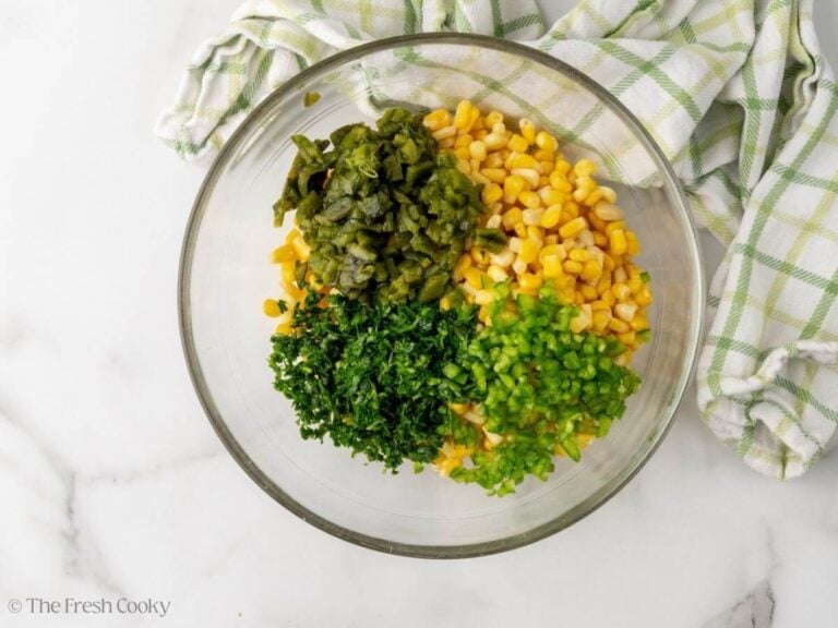 Corn, poblano pepper, jalapeno pepper and cilantro in a large bowl.