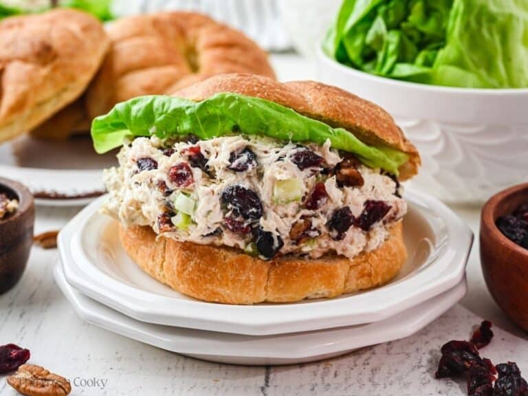 Cranberry chicken salad stuffed into a flaky croissant with a piece of butter lettuce.