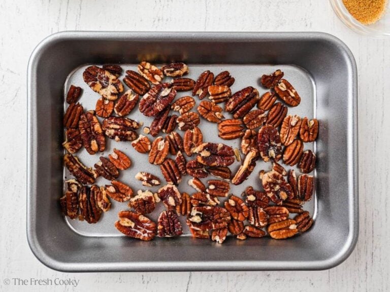 Toasted walnuts spread out in a baking dish.