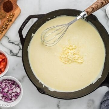 Whisking in mozzarella and sharp cheddar cheese to queso base.