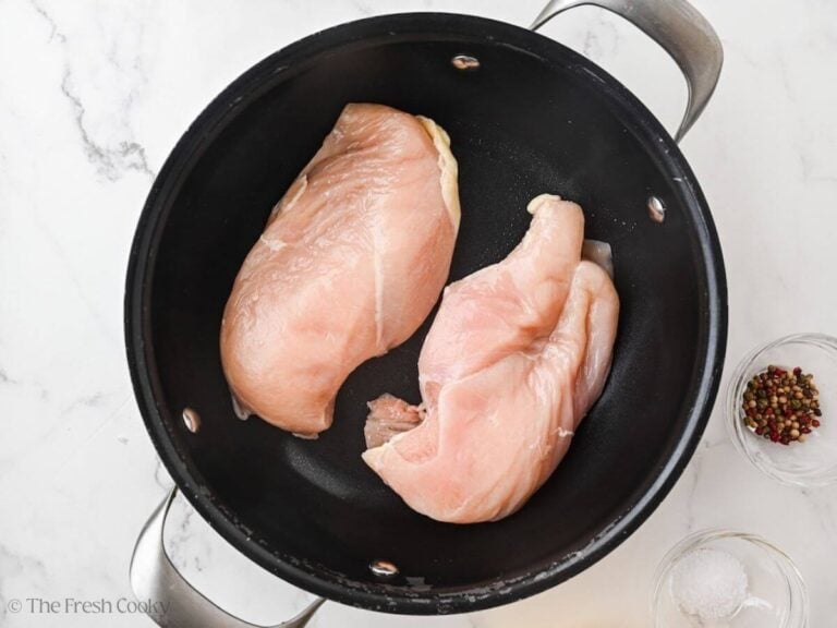 Two chicken breasts in a pot of water.
