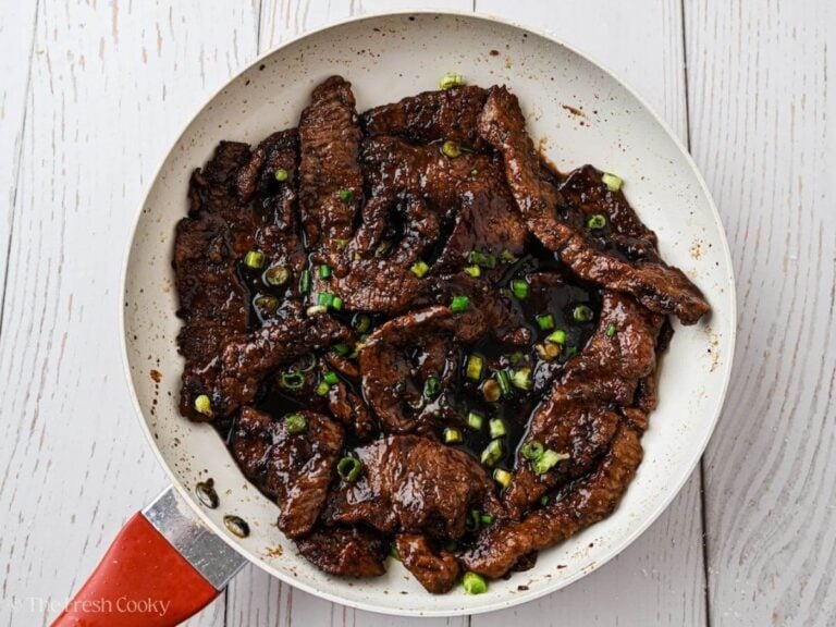 Mongolian beef in saucepan with sauce poured over.
