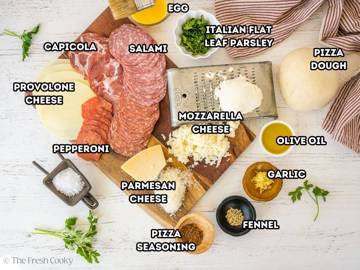 Stromboli Ingredients, L-R Provolone, Capicola, Salami, egg wash, Flat leaf parsely, pizza dough, olive oil, garlic, fennel pizza seasoning, mozzarella, parmesan cheese, flaky sea salt and pepperoni.
