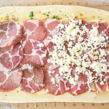 Add capicola and any meats and top with shredded mozzarella.