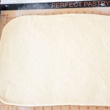 Pizza dough rolled into large rectangle.
