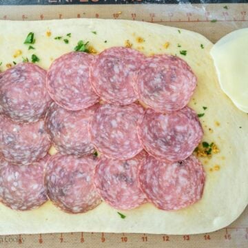 Adding salami to the dough.