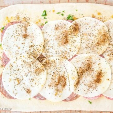 Add provolone and sprinkle with pizza seasoning (Italian seasoning).