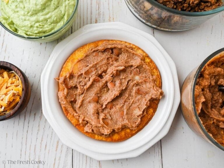 Tostada spread with warm refried beans.