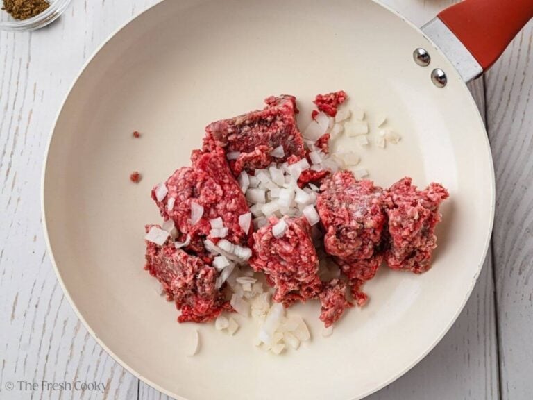 Ground beef and onions in skillet.