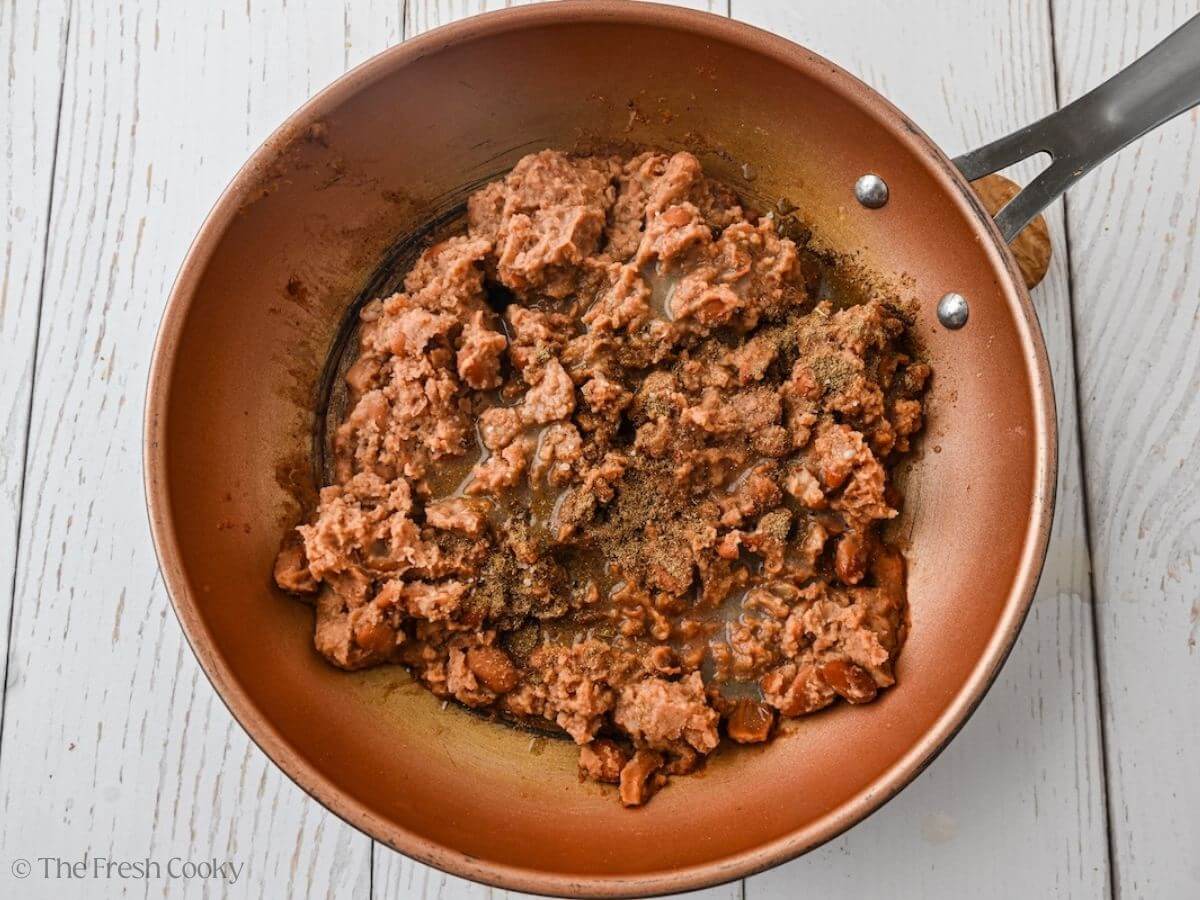 Warm up the refried beans in a skillet.
