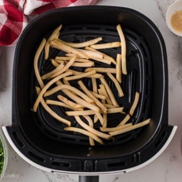 Fries in an air fryer basket.