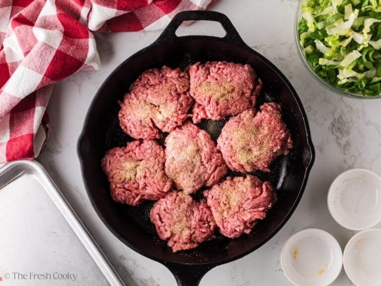 Hamburger patties in a skillet to sear.
