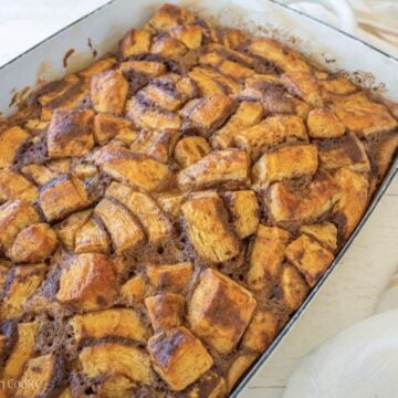Baked breakfast Cinnamon roll casserole in pretty white baking dish.