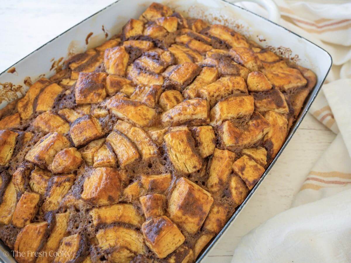Baked breakfast Cinnamon roll casserole in pretty white baking dish.