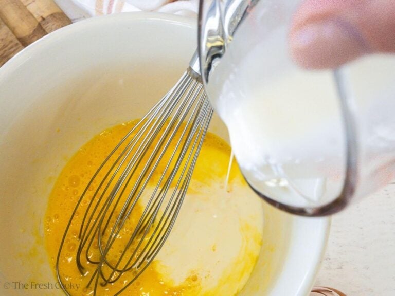 Adding heavy cream to eggs and vanilla for custard.