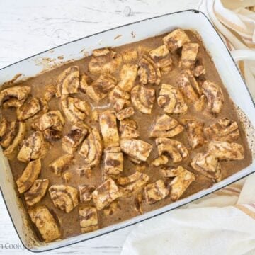 Cinnamon roll casserole and custard spread into prepared pan.