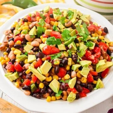 Cowboy caviar in a bowl with avocado, topped with cilantro.