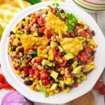 Overhead shot of cowboy caviar in a bowl with some tortilla chips in it.
