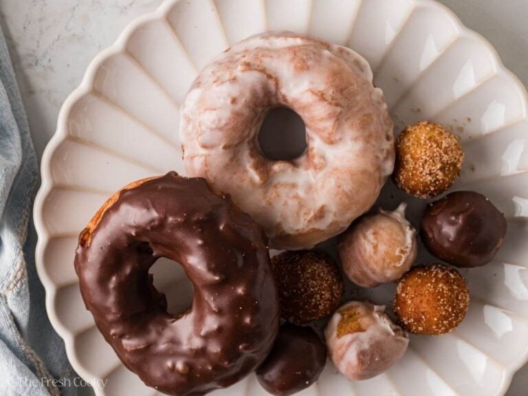 Overhead shot of two donuts with donut holes on a plate.