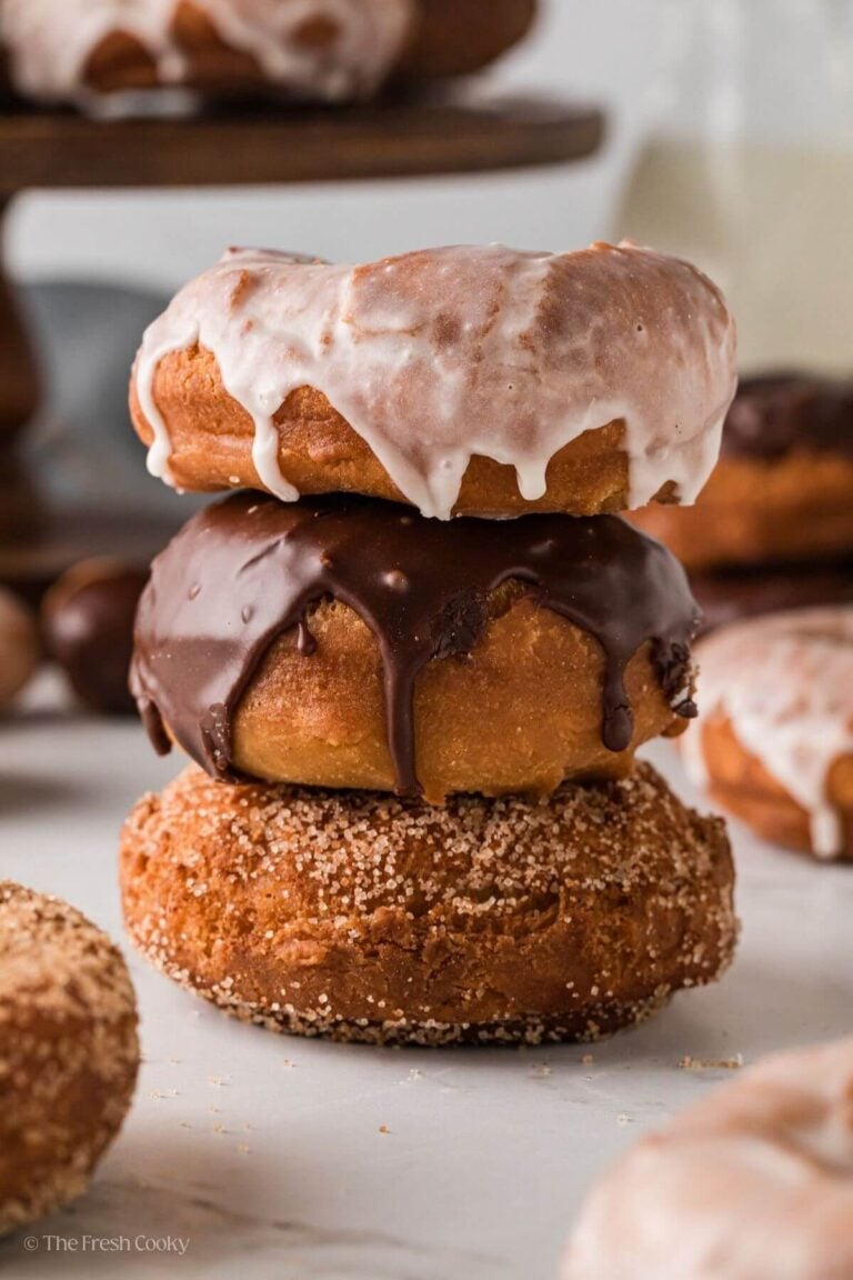 Side view of three homemade donuts stacked on top of each other.