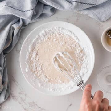 Whisking together the donut glaze in a bowl.