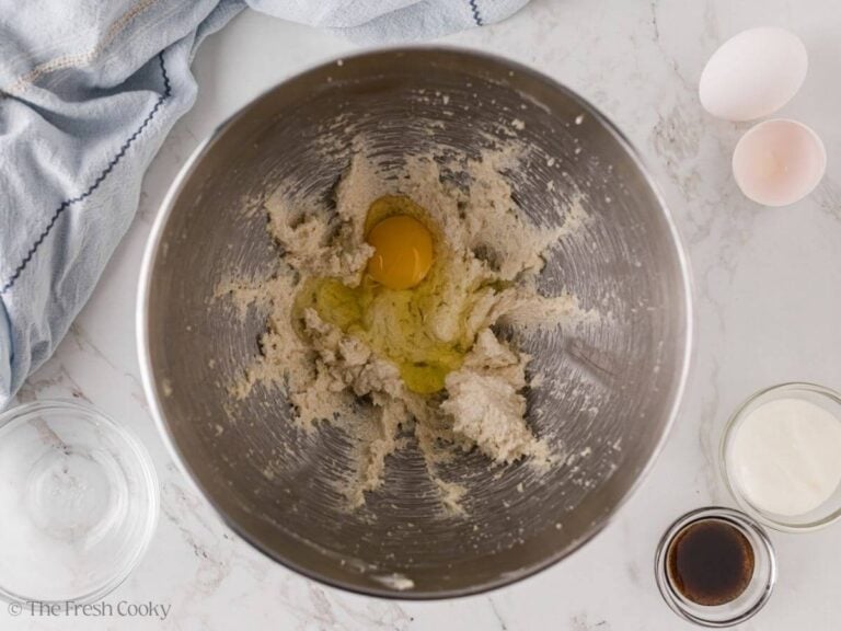 Egg added to the creamed butter and sugar in a mixing bowl.