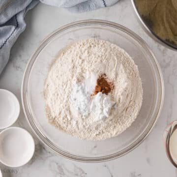 Flour, baking powder, baking soda, salt and nutmeg in a bowl.