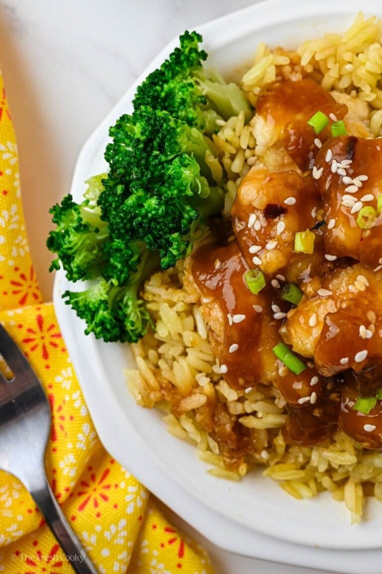 Overhead shot of a plate with rice, orange chicken and broccoli.