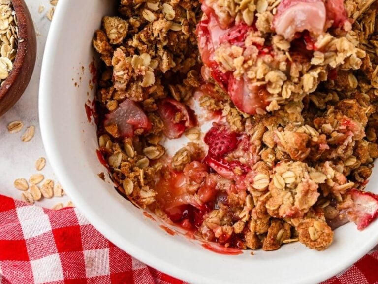 Close up of a strawberry crumble in a white baking dish.