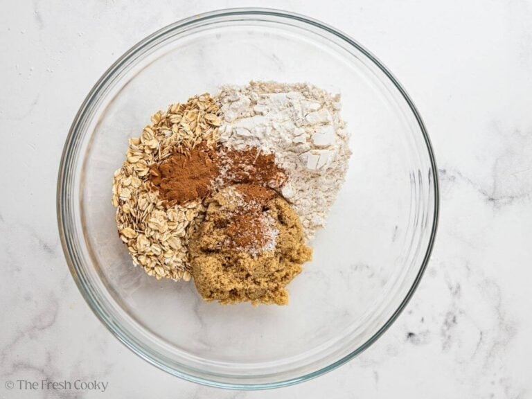 Oats, flour, sugar and spices in a mixing bowl.