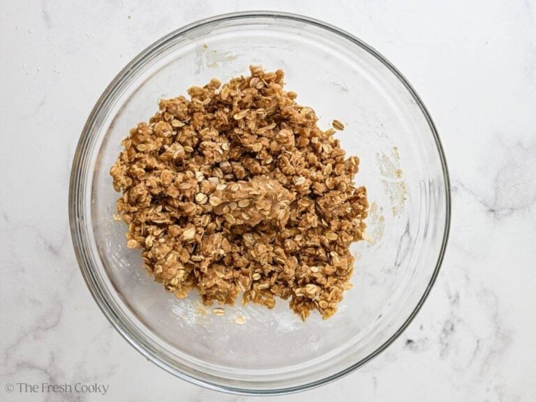 Oat crumble mixture combined in a glass mixing bowl.