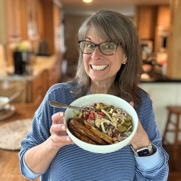 Kathleen Holding a homemade burger bowl with from scratch air fryer steak fries.