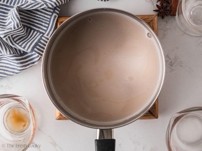Simmered chai tea with milk in a saucepan.