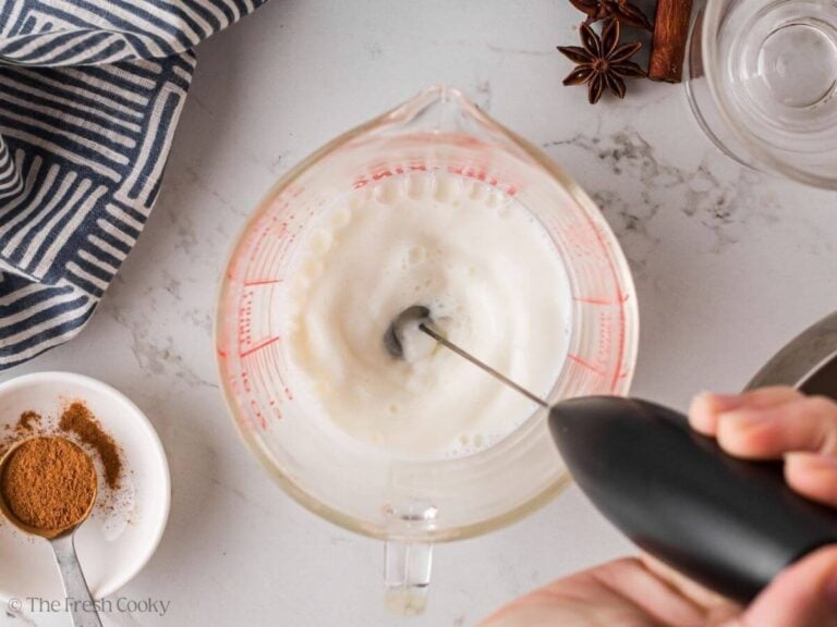 Frothing milk in a measuring cup.