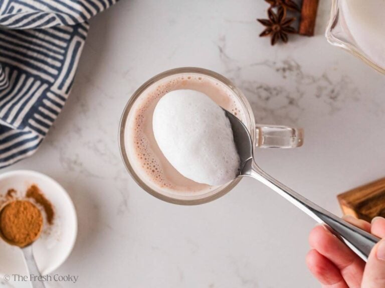 Topping the chai tea latte with frothed milk.