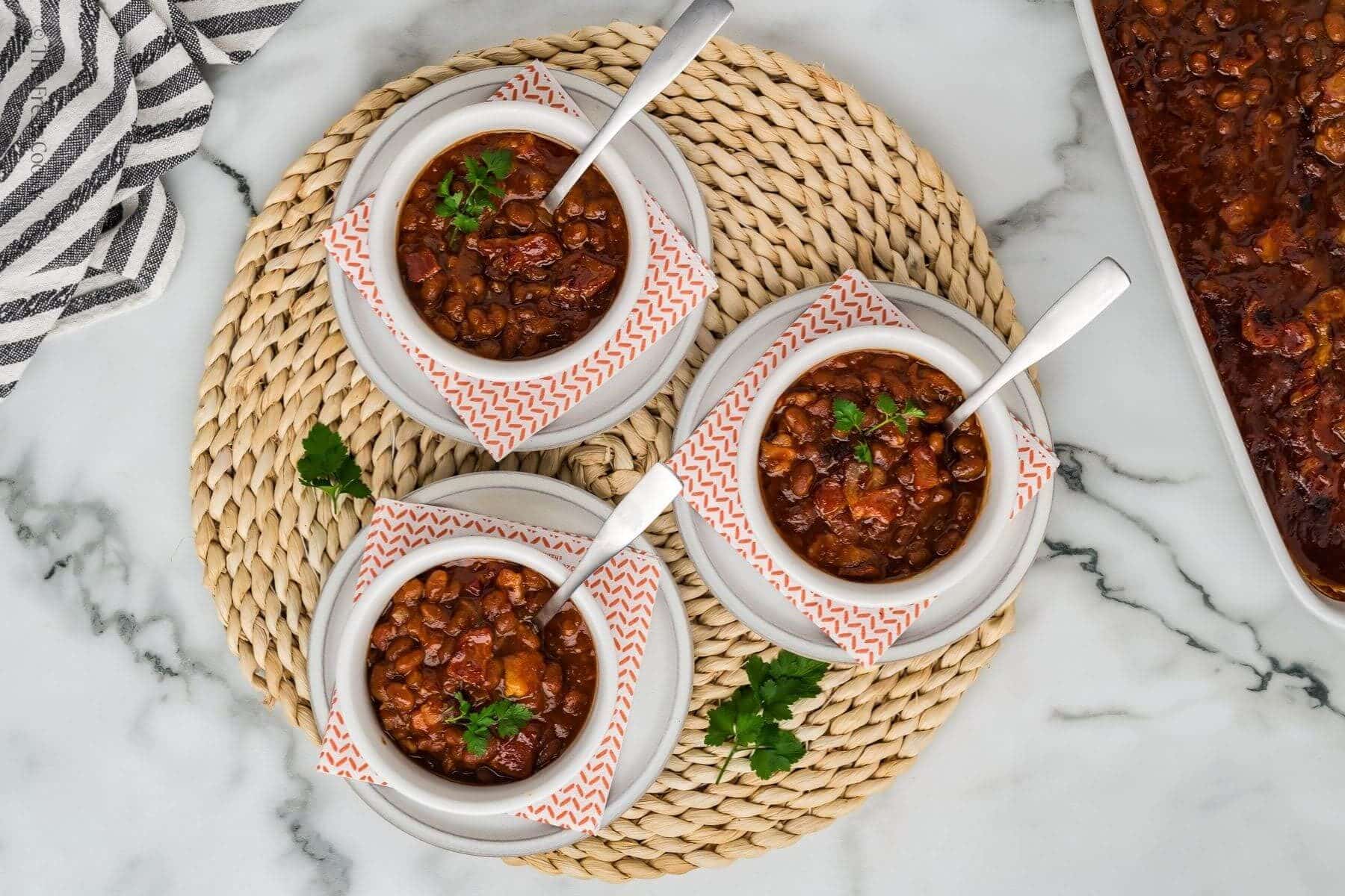 3 serving bowls filled with cowboy baked beans.