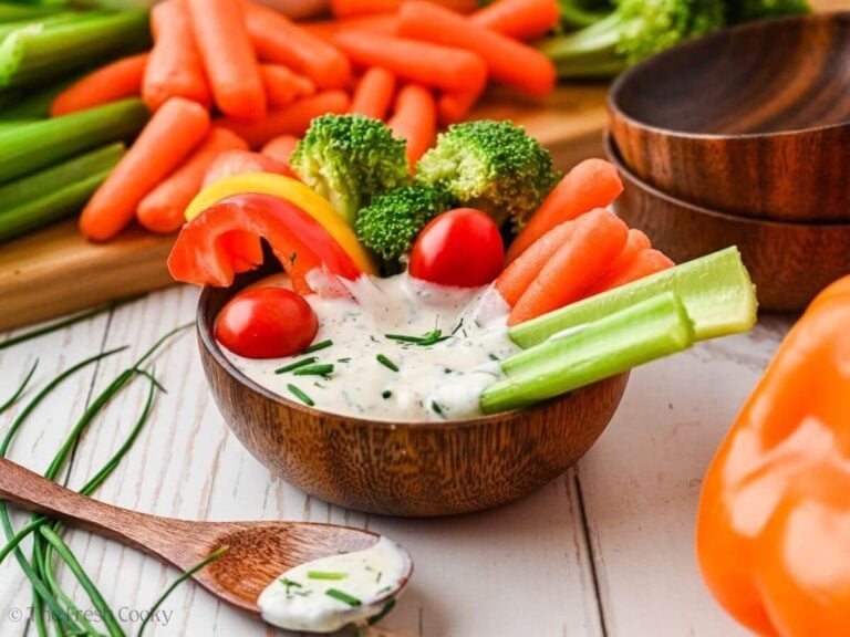 Crudite veggie dip, in a small wooden bowl surrounded by vegetables for dipping.