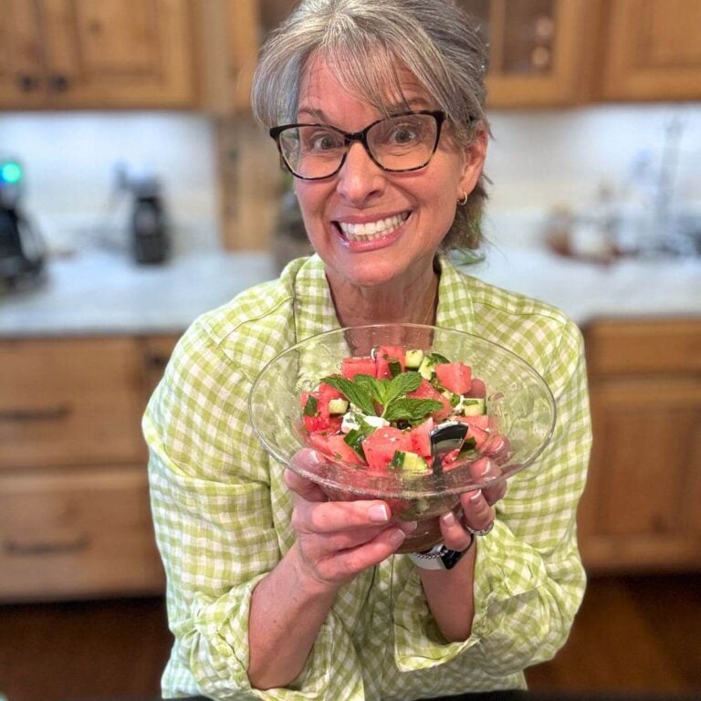 Kathleen (Author) holding a pretty bowl of watermelon, feta salad.