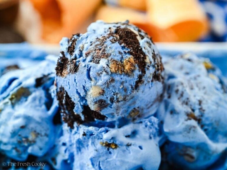 Side view of a scoop of blue monster ice cream in a loaf pan of ice cream.