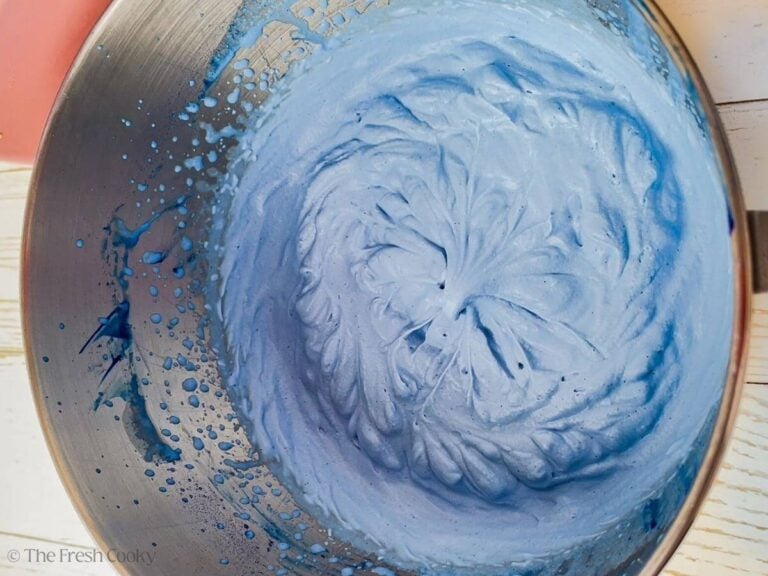 Heavy cream and blue spirulina whipped up in a mixing bowl.