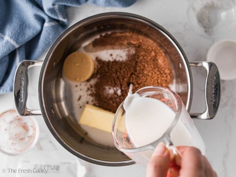 Milk added to the sugar and cocoa mixture in a saucepan.