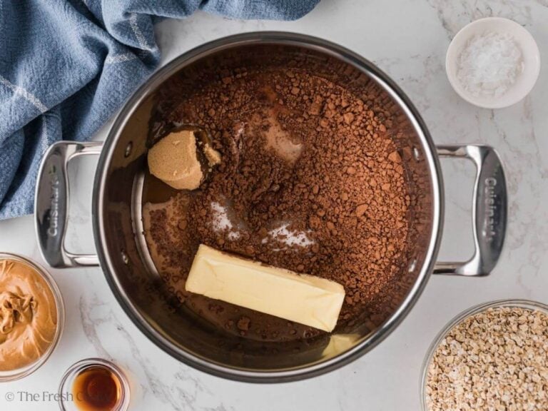 Butter melting into the sugar and cocoa mixture in a saucepan.