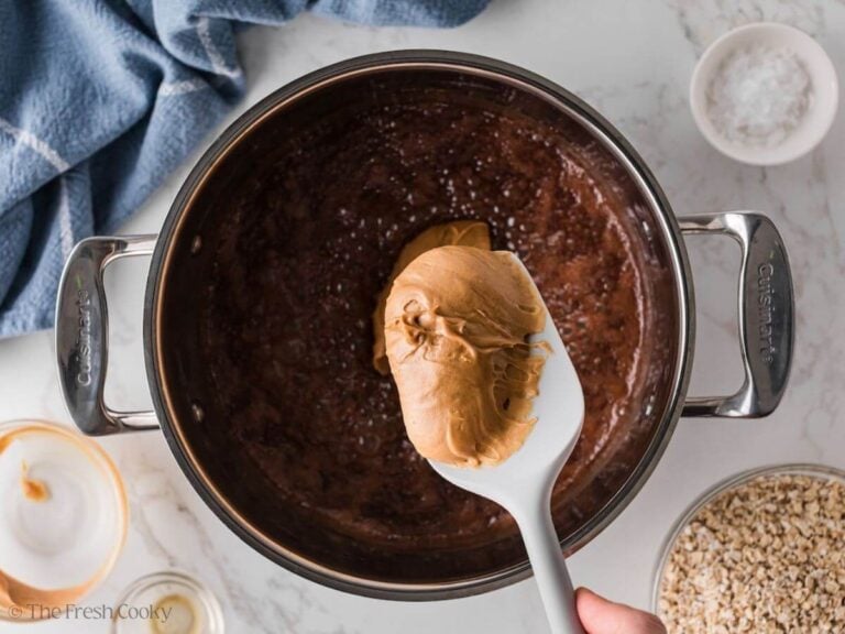 Peanut butter being added to the chocolate mixture in a saucepan.