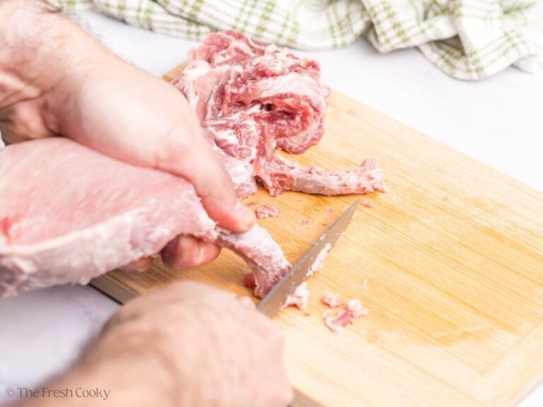 Using a sharp knife, scrape the bone down towards the cutting board.