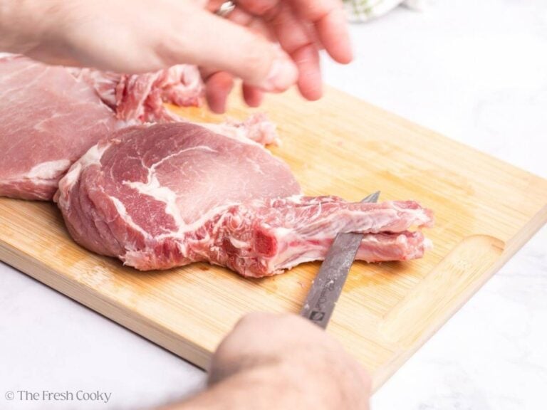 Beginning the frenching process for French cut pork chops, by slicing between the bone and the meat.