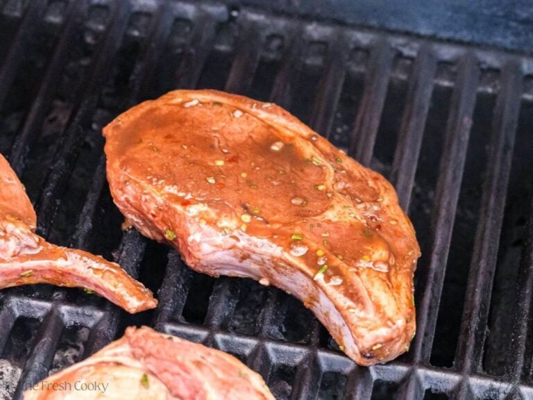 Grilling marinated pork chops on a grill.