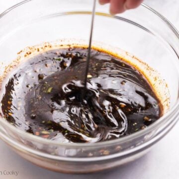 Using a small whisk to mix the pork chop marinade together.